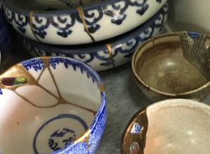 detail photo of a collection of pottery wares repaired via Kintsugi