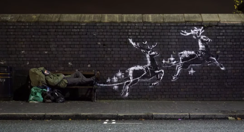 banksy mural of reindeer pulling a public bench