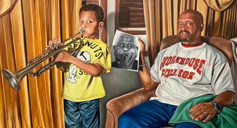 boy playing trumpet, father sits beside him holding a black and white photo