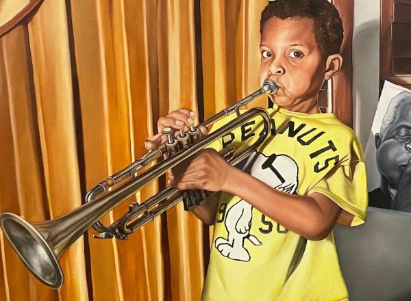 boy playing trumpet, father sits beside him holding a black and white photo